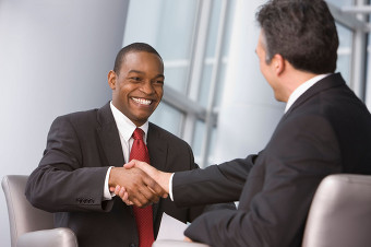 Two men shaking hands at satisfactory outcome